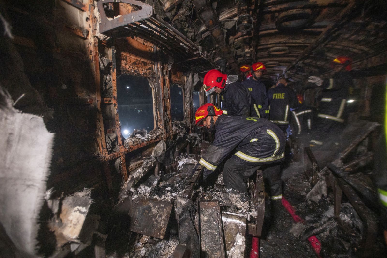 epa11059401 Bangladeshi Firefighters work at the scene of a fire in a passenger train, ahead of general election in Dhaka, Bangladesh, 05 January, 2024. According the Bangladeshi Fire Service and Civil Defence, at least four passengers were killed and several others are injured as Benapole Express was set on fire in the capital's Gopibagh area in Dhaka.  EPA/MONIRUL ALAM