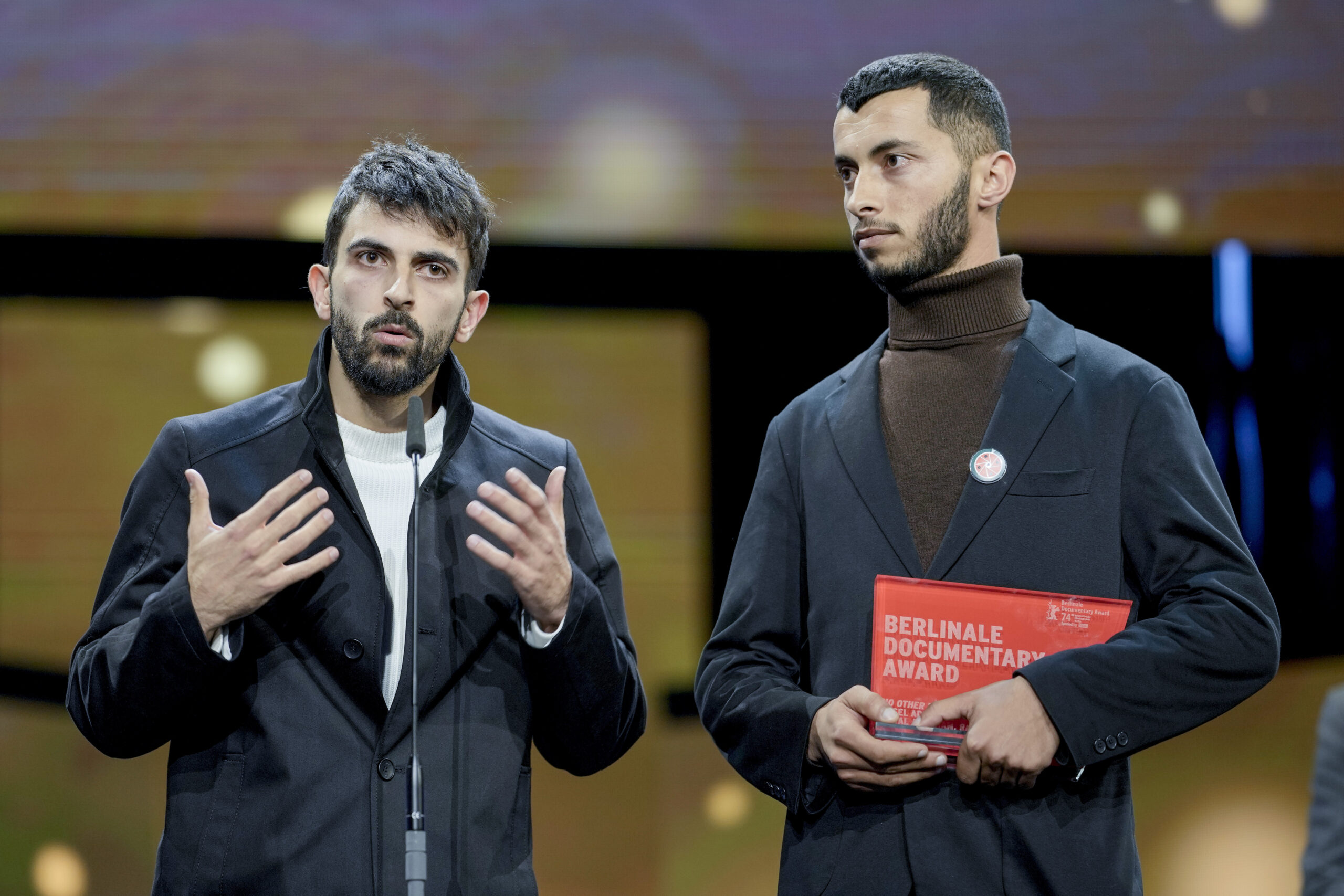 Palestinian Basel Adra, right, and Israeli Yuval Abraham receive the dcoumentary award for "No other land" at the International Film Festival, Berlinale, in Berlin, Saturday, Feb. 24, 2024. (AP Photo/Markus Schreiber)