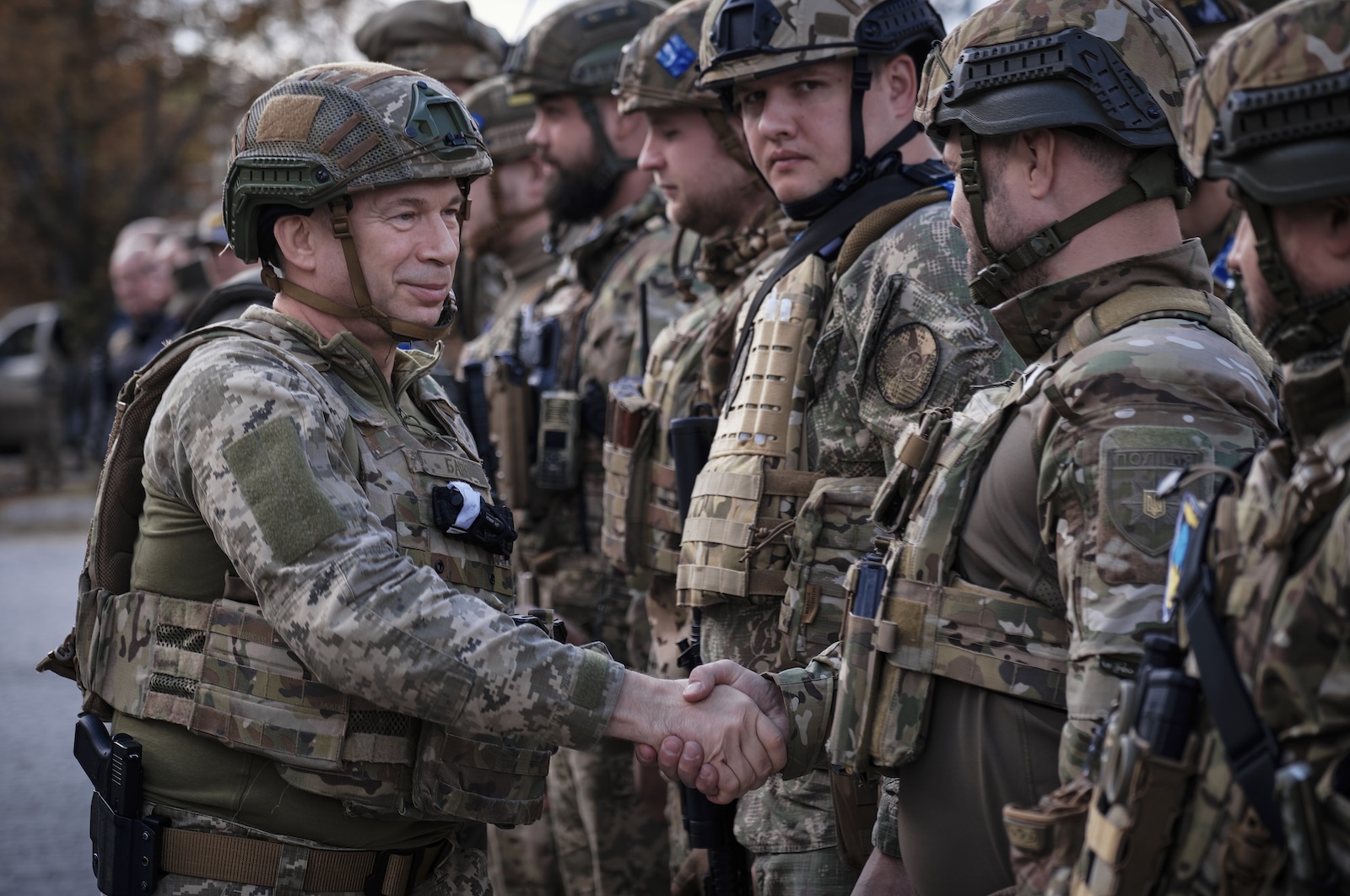 epa11137377 (FILE) - Oleksandr Syrskyi (L), the commander of the Ukrainian Ground Forces, shakes hands with Ukrainian servicemen during a flag raising ceremony in the recently recaptured city of Lyman, Donetsk region, eastern Ukraine, 04 October 2022 (reissued 08 February 2024). On 08 February 2024, Ukraine's President Zelensky removed Commander-in-Chief of the Armed Forces of Ukraine Valerii Zaluzhnyi from his post. Oleksandr Syrskyi, commander of the Ukrainian Ground Forces, has been appointed as new Commander-in-Chief of the country's Armed Forces.  EPA/YEVGEN HONCHARENKO