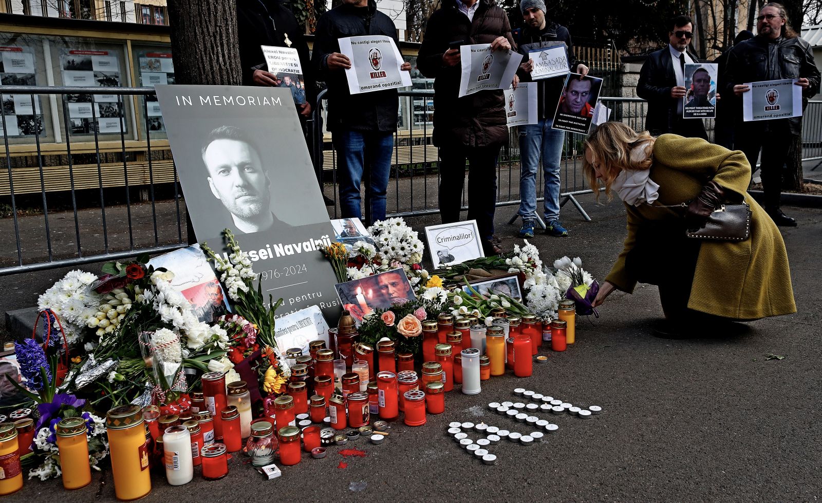 epa11163291 Burning candles and fresh flowers sit around portraits of late Russian opposition leader Alexei Navalny as people gather to pay their respects following his death, outside the Russian Embassy in Bucharest, Romania, 18 February 2024. Russian opposition leader and outspoken Kremlin critic Alexei Navalny has died aged 47 in a penal colony, the Federal Penitentiary Service of the Yamalo-Nenets Autonomous District announced on 16 February 2024. A prison service statement said that Navalny 'felt unwell' after a walk on 16 February, and it was investigating the causes of his death. In late 2023, Navalny was transferred to an Arctic penal colony considered one of the harshest prisons.  EPA/ROBERT GHEMENT