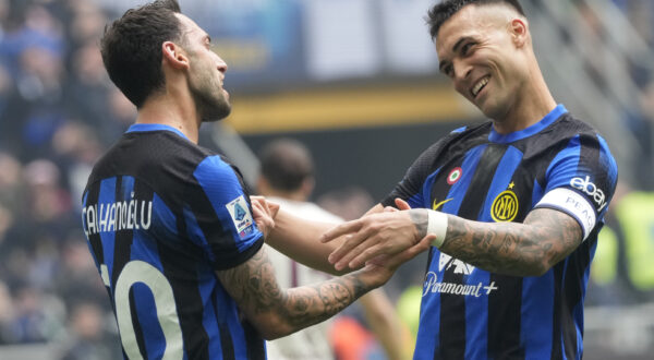 Inter Milan's Hakan Calhanoglu, left, celebrates with Inter Milan's Lautaro Martinez after scoring his side's second goal from a penalty kick during a Serie A soccer match between Inter Milan and Torino at the San Siro stadium in Milan, Italy, Sunday, April 28, 2024. (AP Photo/Luca Bruno)