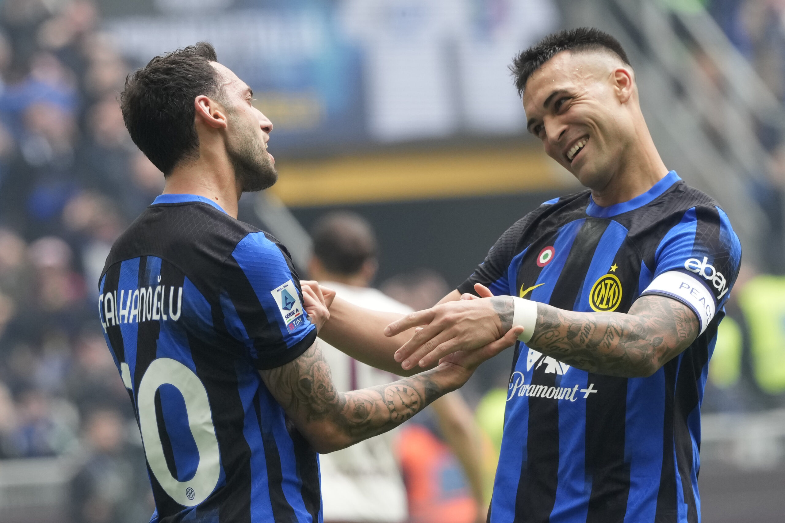 Inter Milan's Hakan Calhanoglu, left, celebrates with Inter Milan's Lautaro Martinez after scoring his side's second goal from a penalty kick during a Serie A soccer match between Inter Milan and Torino at the San Siro stadium in Milan, Italy, Sunday, April 28, 2024. (AP Photo/Luca Bruno)