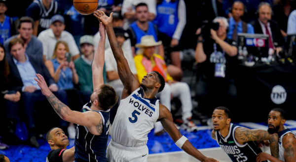 Dallas Mavericks guard Luka Doncic, left, compete for a jump ball against Minnesota Timberwolves guard Anthony Edwards (5) during the second half in Game 3 of the NBA basketball Western Conference finals, Sunday, May 26, 2024, in Dallas. (AP Photo/Gareth Patterson)