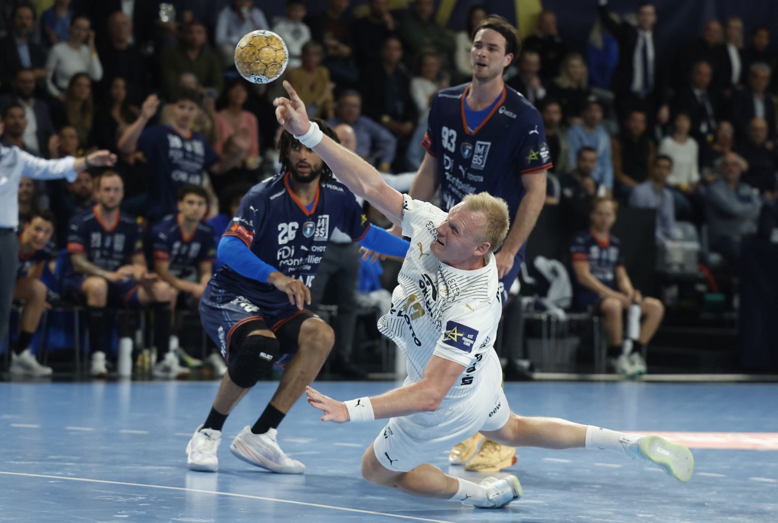 epa11298733 Hugo Bryan Monte Dos santos (L) of Montpellier HB and Patrick Wiencek (C) of THW Kiel in action during the EHF Champions League Round of 8, 1st leg handball match between Montpellier HB and THW Kiel, in Montpellier, France, 24 April 2024.  EPA/Guillaume Horcajuelo