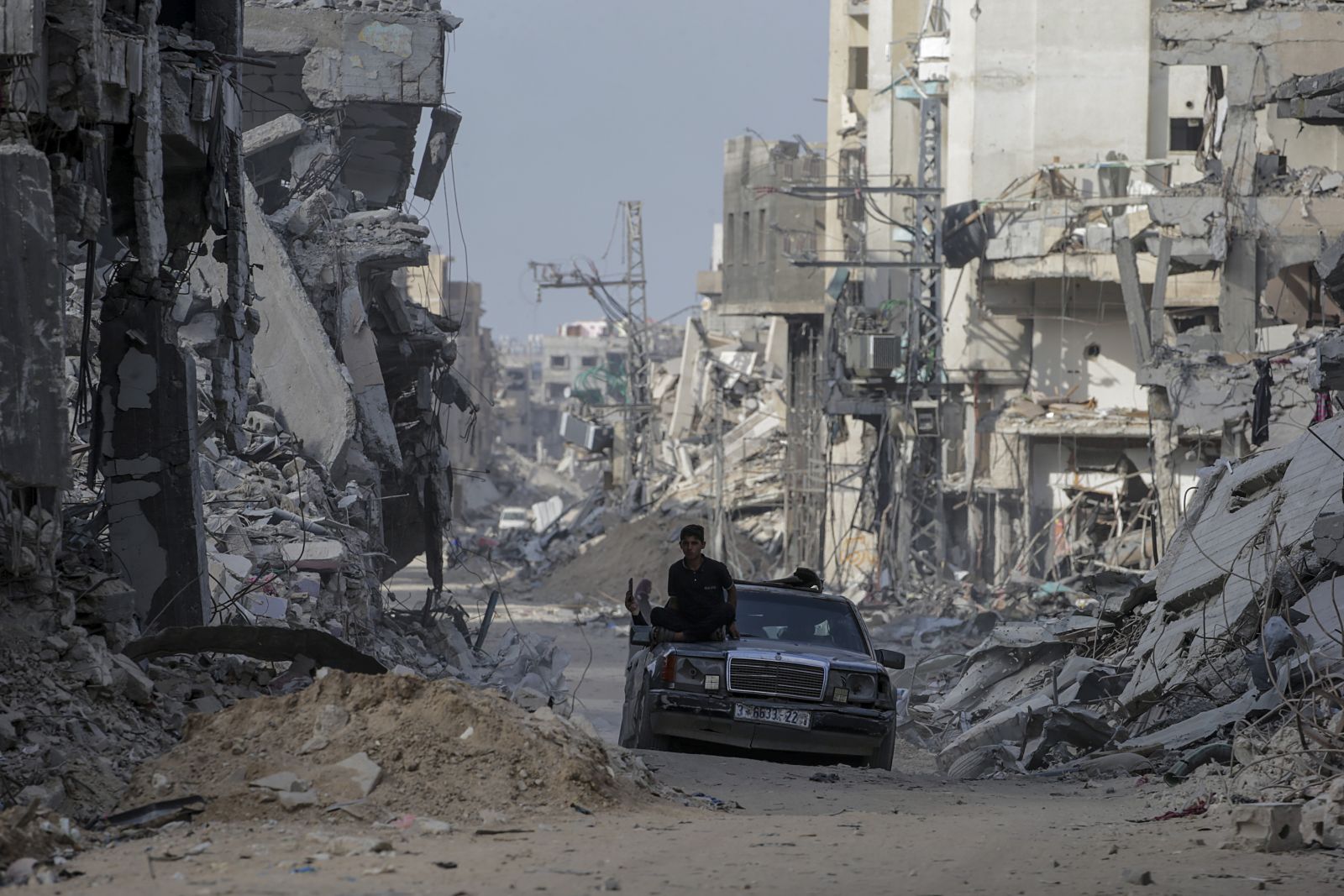 epa11310577 A car drives past destroyed buildings as Palestinians return to Khan Younis after the Israeli military pulled out troops from the southern Gaza Strip, 30 April 2024. According to the United Nations, it will take years to clear the around 23 millions tonnes of rubble and unexploded weapons currently scattered across the Gaza Strip.  EPA/MOHAMMED SABER