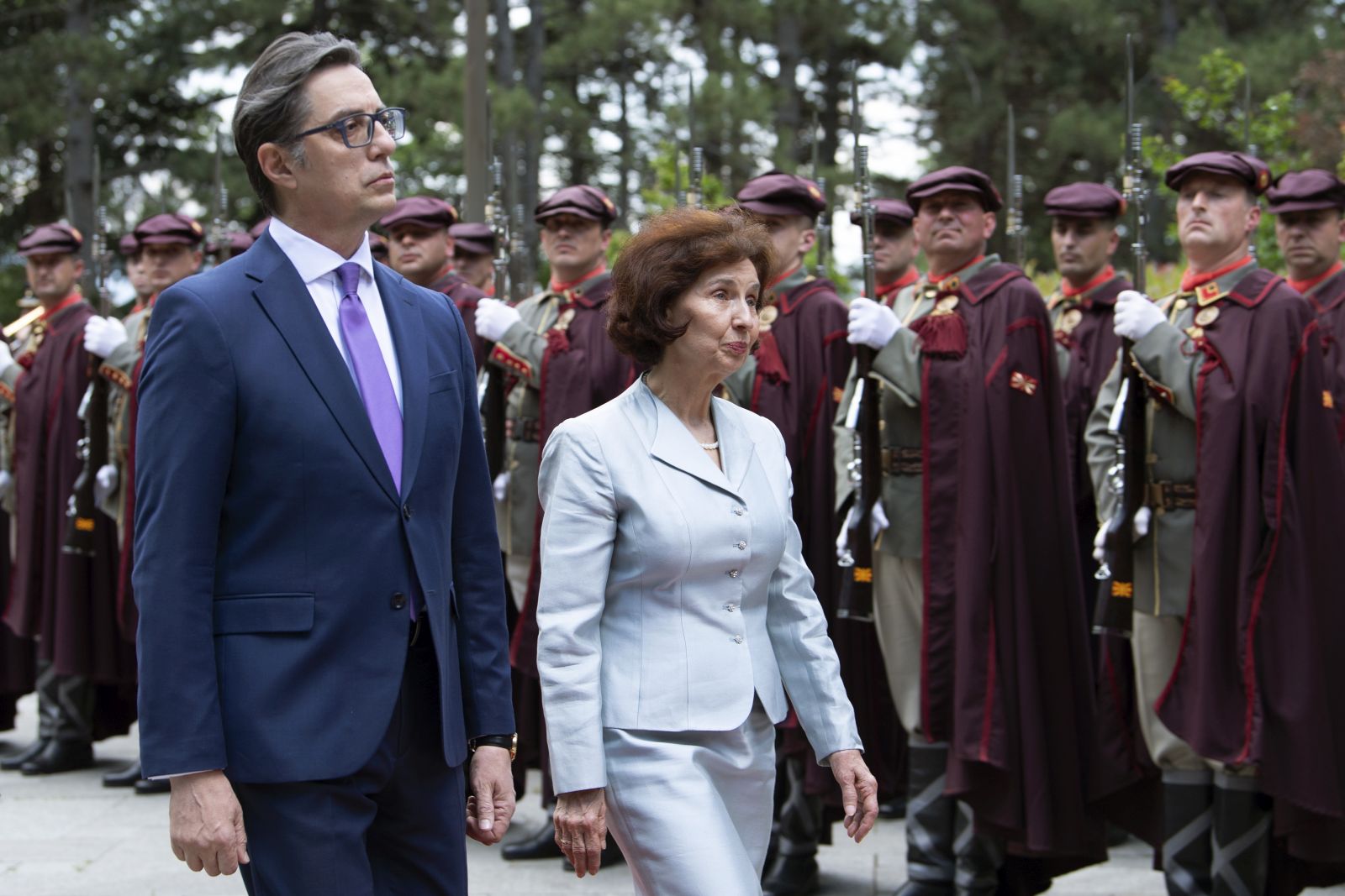 epa11335094 Outgoing President of North Macedonia Stevo Pendarovski (L) and the newly elected President Gordana Siljanovska Davkova (R) inspect the guard of honor during the handover ceremony at the President residence in Skopje in Skopje, North Macedonia, 12 May 2024.  EPA/GEORGI LICOVSKI