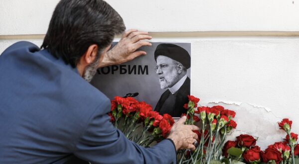 epa11355321 A man places a portrait of the late Iranian President Ebrahim Raisi next to flowers laid outside the Iranian embassy, following the deaths of Iran's president Raisi and Foreign Minister Amir-Abdollahian, in Moscow, Russia, 20 May 2024. According to Iranian state media, President Raisi, Foreign Minister Hossein Amir-Abdollahian and several others were killed in a helicopter crash in the mountainous Varzaghan area on 19 May, during their return to Tehran, after an inauguration ceremony of the joint Iran-Azerbaijan constructed Qiz-Qalasi dam at the Aras river. Iran's first Vice President Mohammad Mokhber was appointed as the country's interim president following the death of Raisi, Iranian supreme leader Ayatollah Ali Khamenei announced in a condolence message on 20 May 2024.  EPA/YURI KOCHETKOV