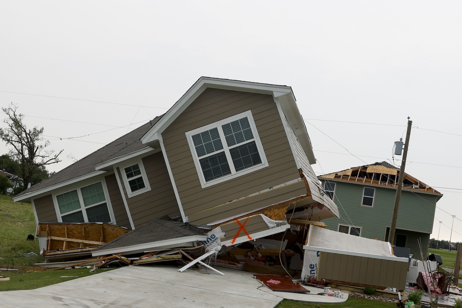 epa11364551 A general view of a house leaning on its side after being hit by a tornado in Temple, Texas, USA, 23 May 2024. According to Temple's fire chief Mitch Randles about 30 people were injured and over 500 homes and businesses impacted, by the tornado that hit Temple on 22 May.  EPA/Adam Davis