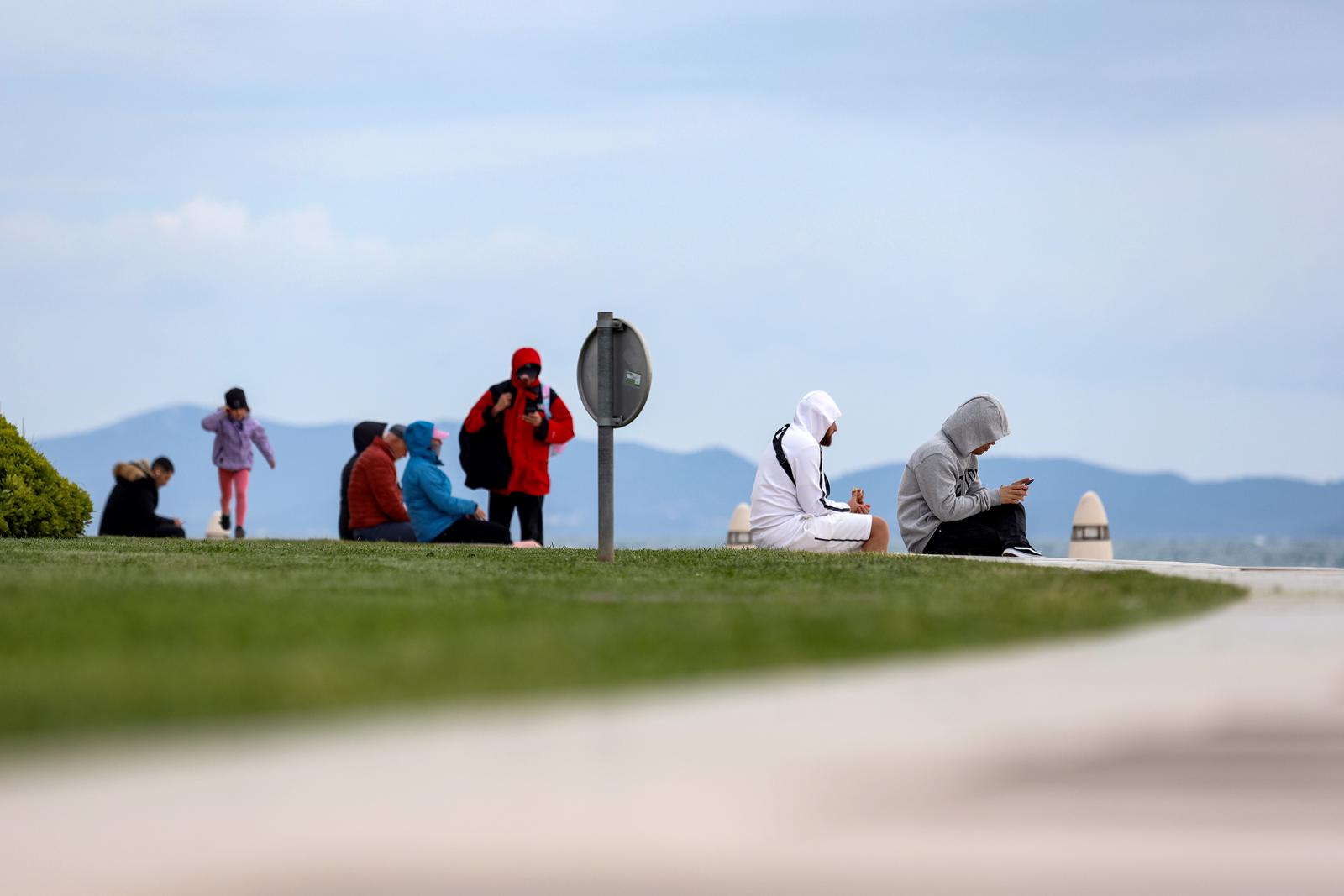 23.04.2024., Zadar - Turisti u razgledavanju grada iako je promjenjivo i vjetrovito vrijeme. Photo: Sime Zelic/PIXSELL