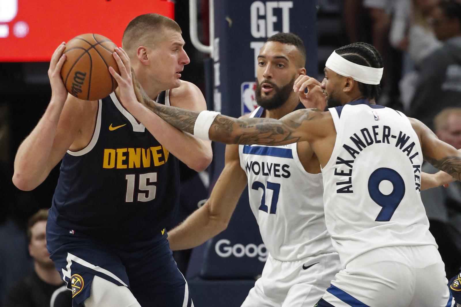 May 12, 2024; Minneapolis, Minnesota, USA; Denver Nuggets center Nikola Jokic (15) works around Minnesota Timberwolves center Rudy Gobert (27) and guard Nickeil Alexander-Walker (9) in the third quarter of game four of the second round for the 2024 NBA playoffs at Target Center. Mandatory Credit: Bruce Kluckhohn-USA TODAY Sports Photo: Bruce Kluckhohn/REUTERS