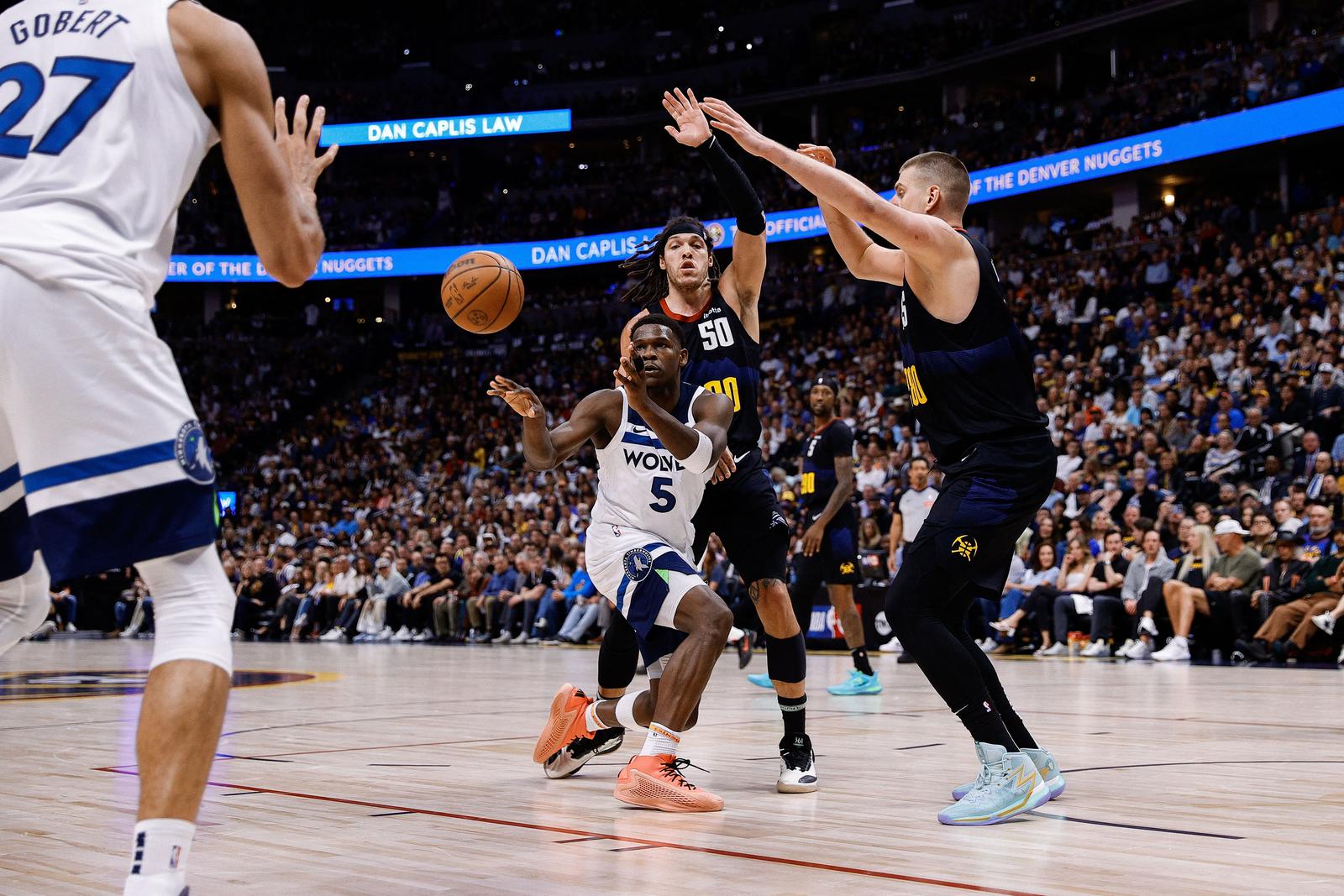 May 14, 2024; Denver, Colorado, USA; Minnesota Timberwolves guard Anthony Edwards (5) passes the ball to center Rudy Gobert (27) as Denver Nuggets forward Aaron Gordon (50) and center Nikola Jokic (15) defend in the second quarter during game five of the second round for the 2024 NBA playoffs at Ball Arena. Mandatory Credit: Isaiah J. Downing-USA TODAY Sports Photo: Isaiah J. Downing/REUTERS