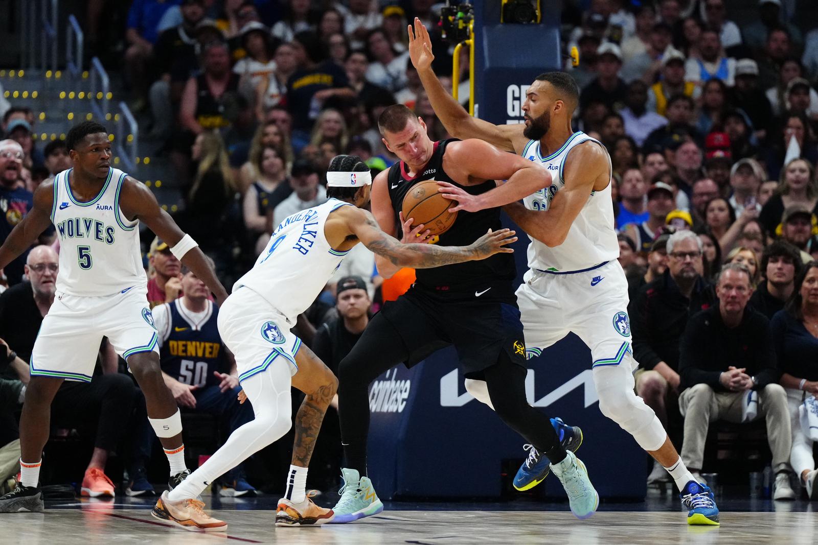 May 19, 2024; Denver, Colorado, USA; Minnesota Timberwolves center Rudy Gobert (27) and guard Nickeil Alexander-Walker (9) defend Denver Nuggets center Nikola Jokic (15) in the first half in game seven of the second round for the 2024 NBA playoffs at Ball Arena. Mandatory Credit: Ron Chenoy-USA TODAY Sports Photo: Ron Chenoy/REUTERS