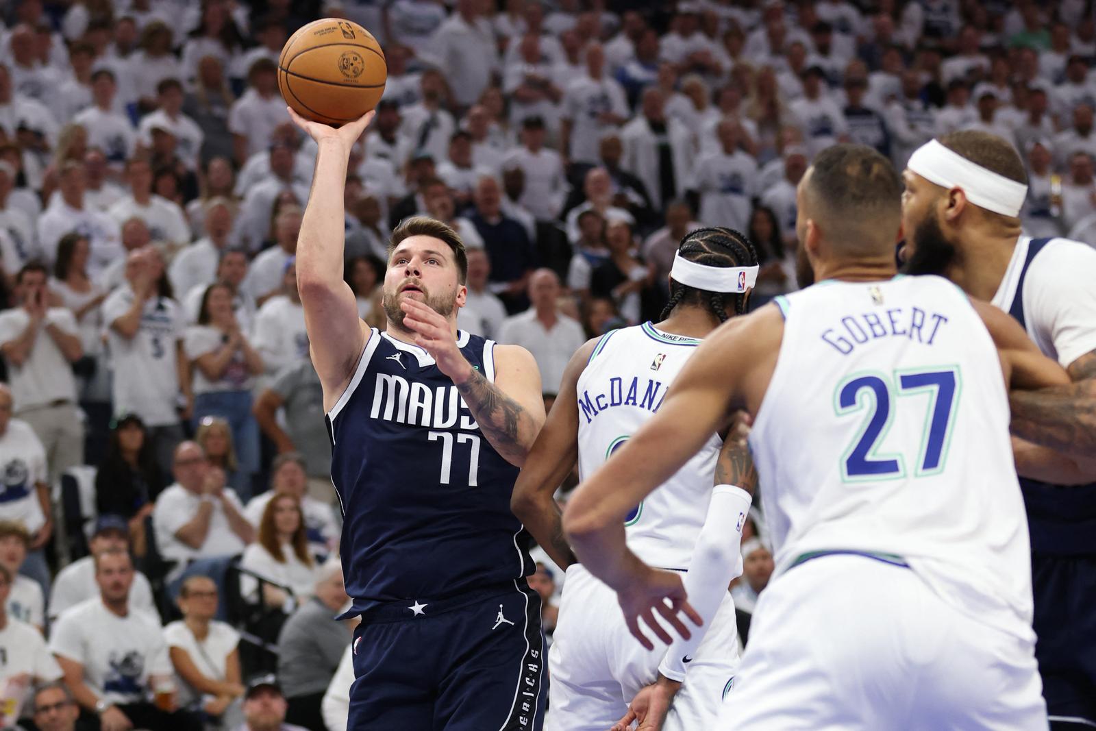 May 22, 2024; Minneapolis, Minnesota, USA; Dallas Mavericks guard Luka Doncic (77) shoots against Minnesota Timberwolves forward Jaden McDaniels (3) in the first quarter during game one of the western conference finals for the 2024 NBA playoffs at Target Center. Mandatory Credit: Jesse Johnson-USA TODAY Sports Photo: Jesse Johnson/REUTERS