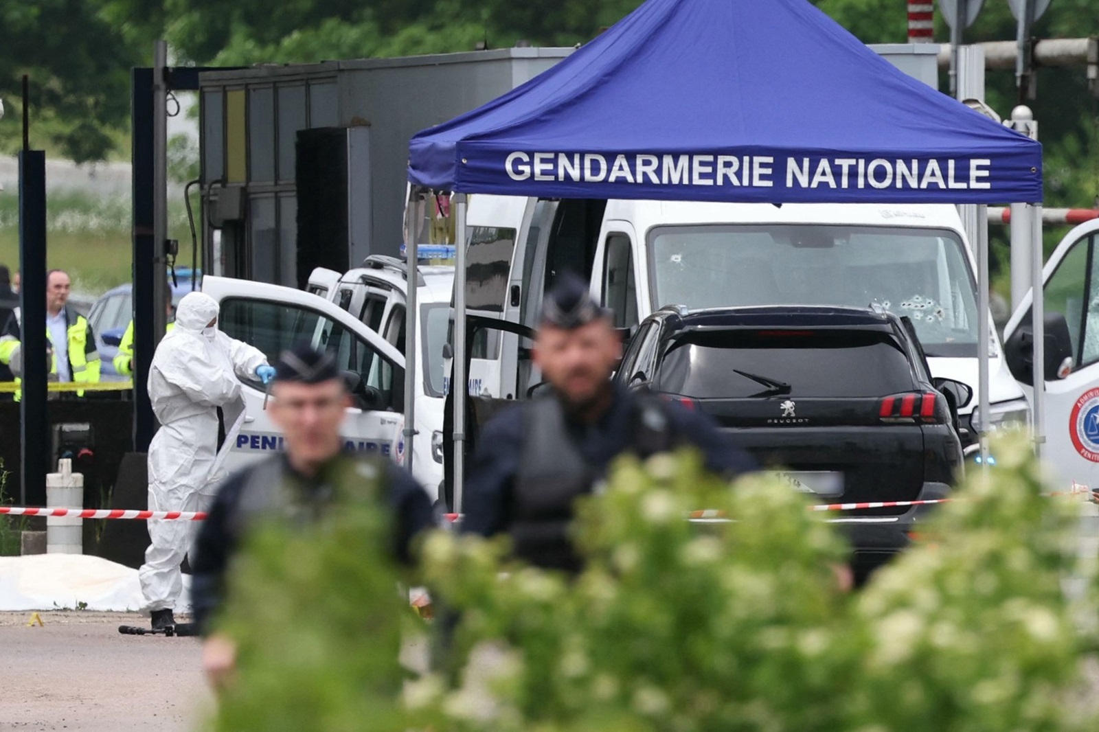 A forensic is at work as police officers patrol at the site of a ramming attack which took place late morning at a road toll in Incarville in the Eure region of northern France, on May 14, 2024. Two French prison officers were killed and two others wounded on May 14 in an attack on a prison van transporting an inmate who escaped, a police source told AFP.,Image: 872872981, License: Rights-managed, Restrictions: , Model Release: no, Credit line: ALAIN JOCARD / AFP / Profimedia