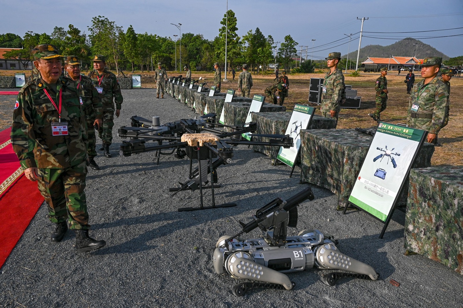 Deputy Commander-in-Chief of the Royal Cambodian Armed Forces and commander of the Royal Cambodian Army, General Mao Sophan (L), inspects drones and a machine gun equipped robot battle "dog" (R) displayed in front of Chinese soldiers during the Cambodian-Chinese Dragon Gold-2024 drill at a military police base in Kampong Chhnang province on May 16, 2024. Cambodia and China began their largest-ever joint annual military drills on May 16, 2024 to boost their army capacity amid US concerns that Beijing could use a key Cambodian naval base to expand its influence in the region.,Image: 873403442, License: Rights-managed, Restrictions: , Model Release: no, Credit line: TANG CHHIN SOTHY / AFP / Profimedia