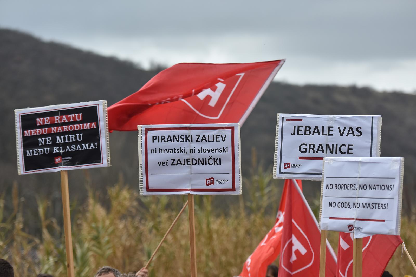 07.01.2018., Granicni prijelaz Plovanija - Odrzan je zajednicki prosvjed Radnicke fronte i Levice, politickih lijevih stranaka iz Hrvatske i Slovenije, u vezi slucaja Piranskog zaljeva.rProsvjedna akcija je odrzana na hrvatsko-slovenskom granicnom prijelazu Plovanija na "nicijoj zemlji". Zajednickom akcijom upozorili su na nacionalisticku maglu koja nam se prodaje na obje strane. Piranski zaljev i sporovi oko njega sluze kako bismo se bavili nepostojecim nacionalnim pitanjima, a ne gorucim problemima gospodarske i socijalne politike.rNa prosvjedu se okupilo 50-tak clanova i clanica Radnicke fronte i Levice iz svih krajeva Slovenije i Hrvatske, te su na hrvatskom, slovenskom i talijanskom jeziku, pred mnostvom novinara i medijskih kuca, procitali zajednicko priopcenje. rPhoto: Dusko Marusic/PIXSELL