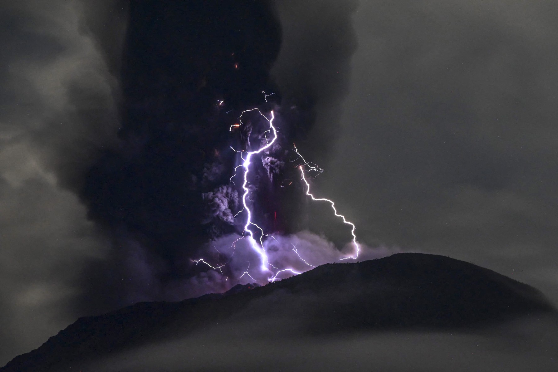 This handout picture taken and released on May 18, 2024 by the Indonesian Geological Agency shows Mount Ibu spewing volcanic ash as lightning strikes, as seen from the monitoring post in West Halmahera, North Maluku.,Image: 874128154, License: Rights-managed, Restrictions: RESTRICTED TO EDITORIAL USE - MANDATORY CREDIT "AFP PHOTO /  INDONESIAN GEOLOGICAL AGENCY " - NO MARKETING NO ADVERTISING CAMPAIGNS - DISTRIBUTED AS A SERVICE TO CLIENTS, ***
HANDOUT image or SOCIAL MEDIA IMAGE or FILMSTILL for EDITORIAL USE ONLY! * Please note: Fees charged by Profimedia are for the Profimedia's services only, and do not, nor are they intended to, convey to the user any ownership of Copyright or License in the material. Profimedia does not claim any ownership including but not limited to Copyright or License in the attached material. By publishing this material you (the user) expressly agree to indemnify and to hold Profimedia and its directors, shareholders and employees harmless from any loss, claims, damages, demands, expenses (including legal fees), or any causes of action or allegation against Profimedia arising out of or connected in any way with publication of the material. Profimedia does not claim any copyright or license in the attached materials. Any downloading fees charged by Profimedia are for Profimedia's services only. * Handling Fee Only 
***, Model Release: no, Credit line: Handout / AFP / Profimedia