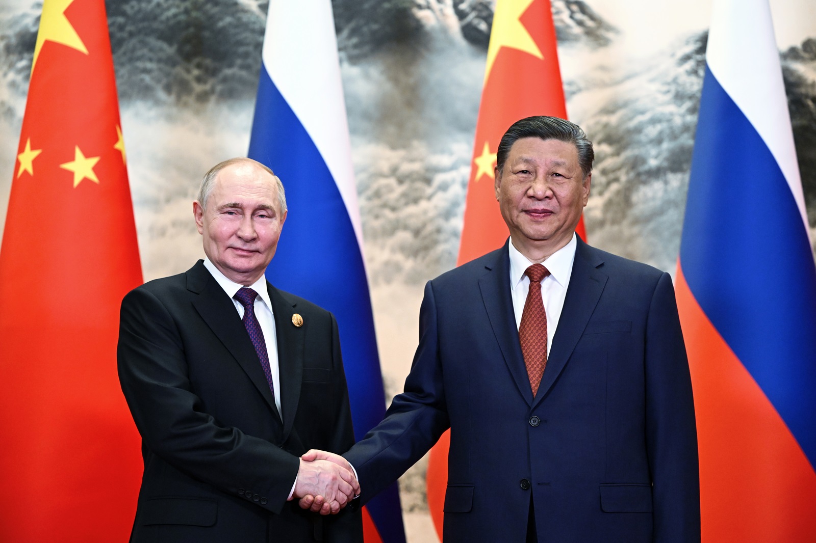 epa11343937 Russian President Vladimir Putin (L) and Chinese President Xi Jinping shake hands as they pose for photos before a meeting in narrow format at the Great Hall of the People in Beijing, China, 16 May 2024. The Russian president is on an official visit to China on 16 and 17 May.  EPA/SERGEY GUNEEV / SPUTNIK / KREMLIN POOL MANDATORY CREDIT