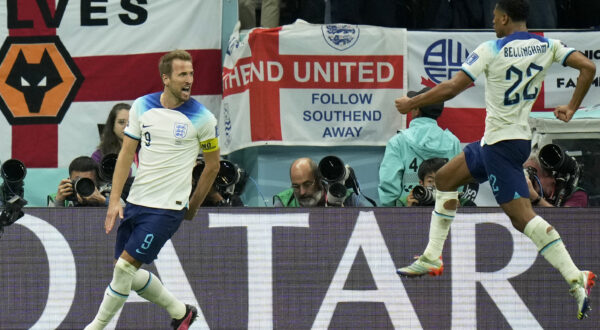 England's Harry Kane celebrates with Jude Bellingham, right, after scoring his side's first goal from the penalty spot during the World Cup quarterfinal soccer match between England and France, at the Al Bayt Stadium in Al Khor, Qatar, Saturday, Dec. 10, 2022. (AP Photo/Francisco Seco)