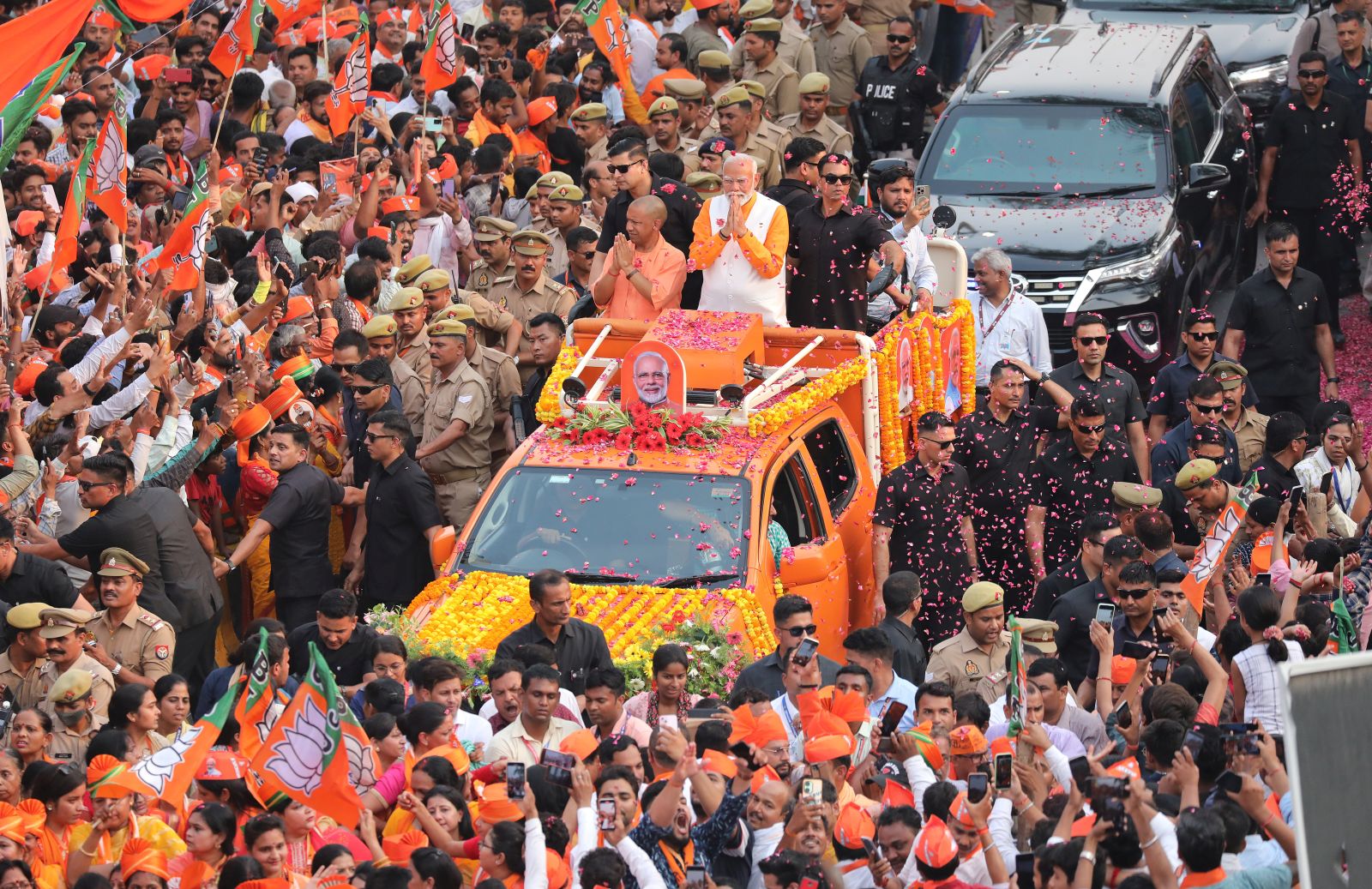 epa11336936 Top Bhartya Janta party (BJP) leader and Indian Prime Minister Narendra Modi (R) and Chief Minsiter of Uttar Pradesh, Yogi Adityanath (L) gesture to their supporters during a road show in Varanasi, Uttar Pradesh, India, 13 May 2024. Prime Minister Narendra Modi will file his election nomination on 14 May 2024, from the Varanasi constituency for the parliamentary or general elections for India's 545-member lower house of parliament, or Lok Sabha, that is held every five years. The Indian general elections are held in seven phases between 19 April and 01 June 2024, with the results announced on 04 June 2024.  EPA/HARISH TYAGI