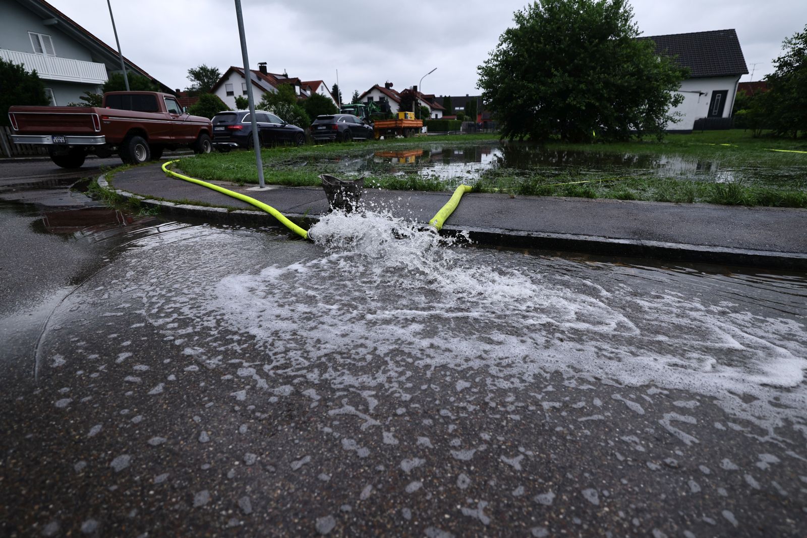 epa11387263 Water from flooded houses is pumped out in Baar-Ebenhausen, in Germany, 03 June 2024. Heavy rain causes flooding in the southern states of Germany in Bavaria and Baden-Wuerttemberg.  EPA/ANNA SZILAGYI