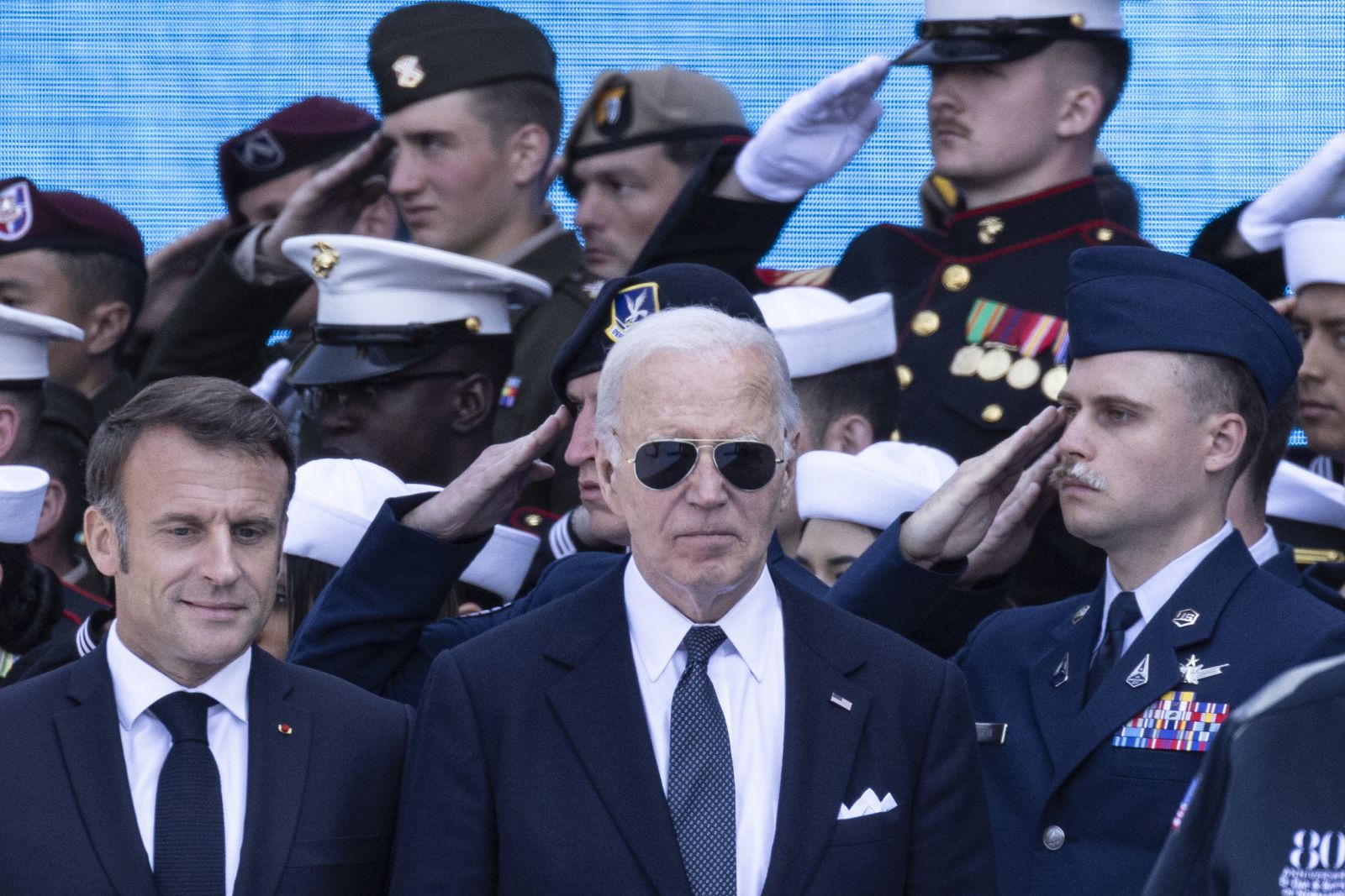 epa11394632 US President Joe Biden (C) and French President Emmanuel Macron (L) arrive to attend a commemorative ceremony for the 80th anniversary of D-Day landings in Normandy at American War Cemetery in Colleville-sur-Mer, France, 06 June 2024. More than 160,000 Western allied troops landed on beaches in Normandy on 06 June 1944 launching the liberation of Western Europe from Nazi occupation during World War II.  EPA/ANDRE PAIN