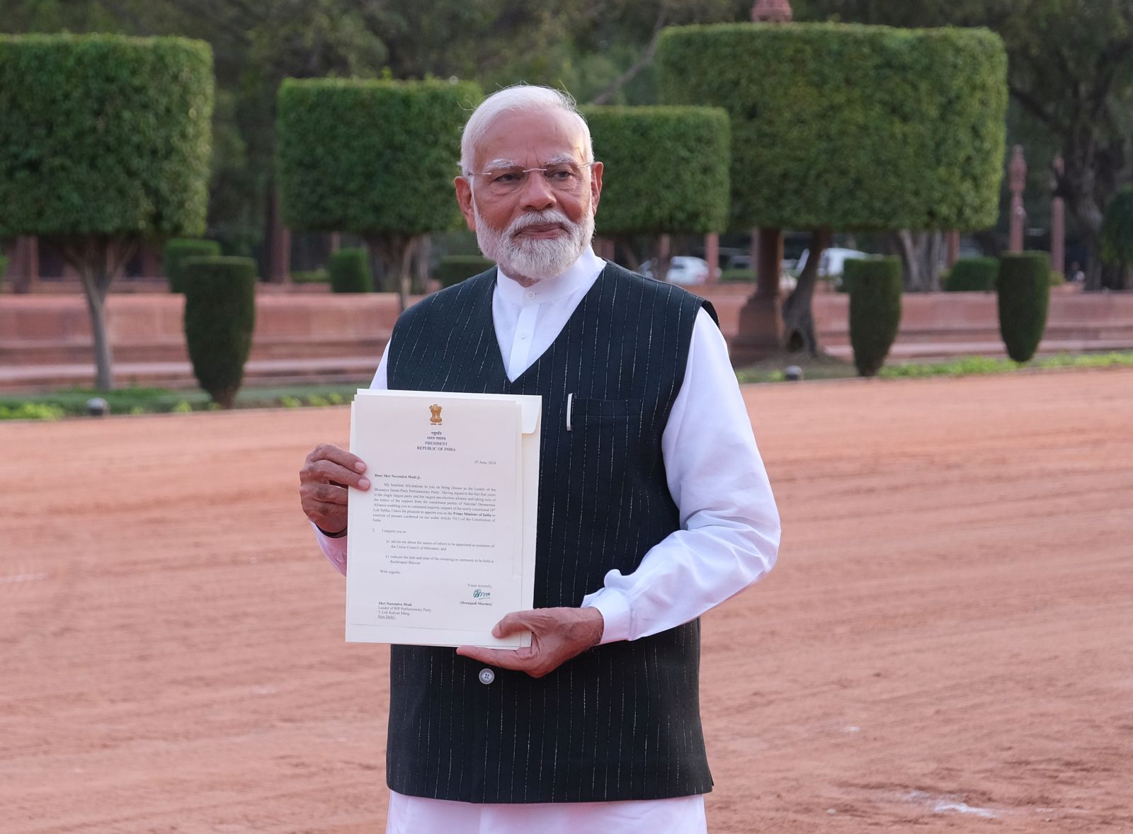 epa11395916 Indian Prime Minister Narendra Modi, shows a letter by Indian President Droupadi Murmu, inviting him to form the Indian Government while delivering a speech after meeting Indian President at the presidential official residence Rashtrapati Bhavan, in New Delhi, India, 07 June 2024. Narendra Modi will be sworn-in as Indian Prime Minister on 09 June 2024.  EPA/T. NARAYAN
