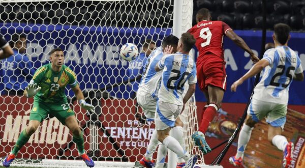 epa11427124 Cyle Larin (2-R) of Canada takes a shot on Emiliano Martinez (L) of Argentina during the second half of the CONMEBOL Copa America 2024 group A soccer match between Argentina and Canada, in Atlanta, Georgia, USA, 20 June 2024.  EPA/ERIK S. LESSER