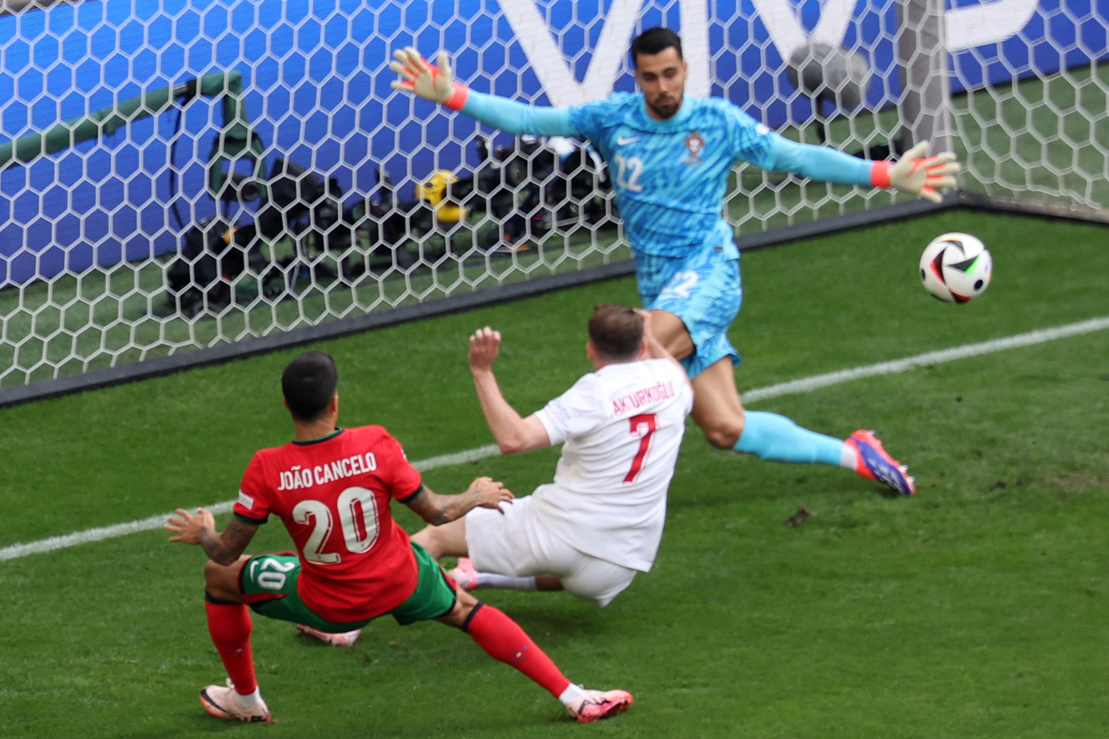 epa11430675 Muhammed Kerem Aktuerkoglu of Turkey (C) in action against goalkeeper Diogo Costa (R) and Joao Cancelo of Portugal during the UEFA EURO 2024 group F soccer match between Turkey and Portugal, in Dortmund, Germany, 22 June 2024.  EPA/CHRISTOPHER NEUNDORF