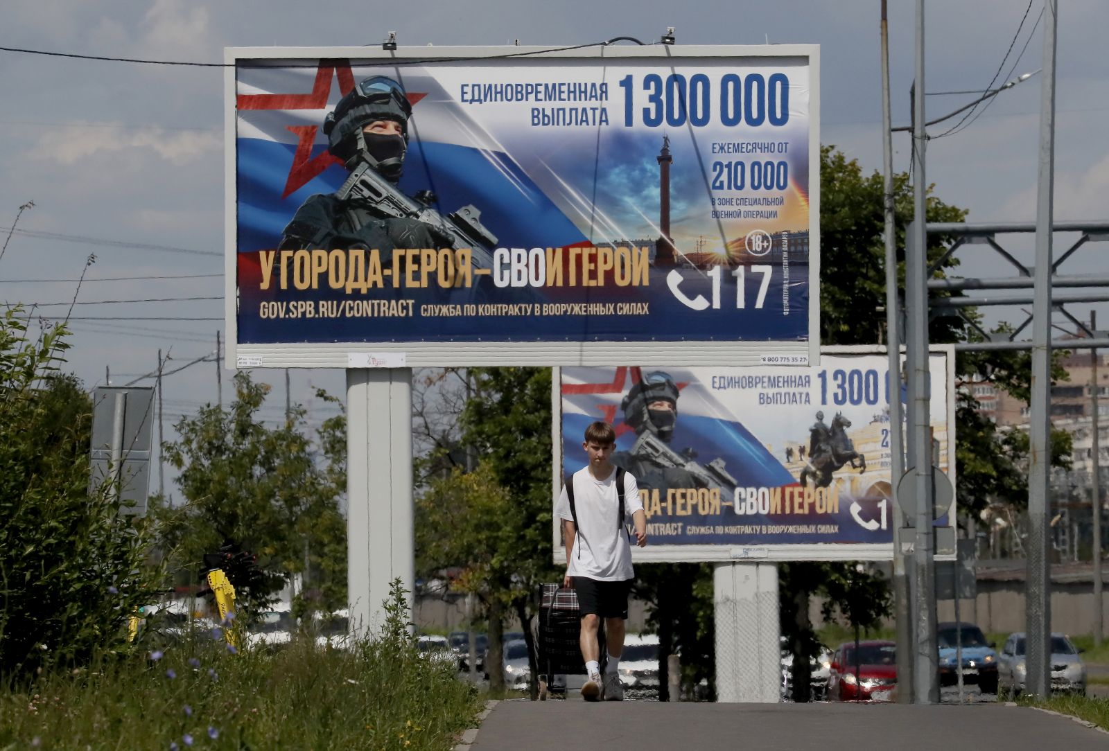 epa11436129 A man walks in front of billboards advertising to join military service with the slogan 'A heroic city has its heroes' in St. Petersburg, Russia, 25 June 2024.  EPA/ANATOLY MALTSEV
