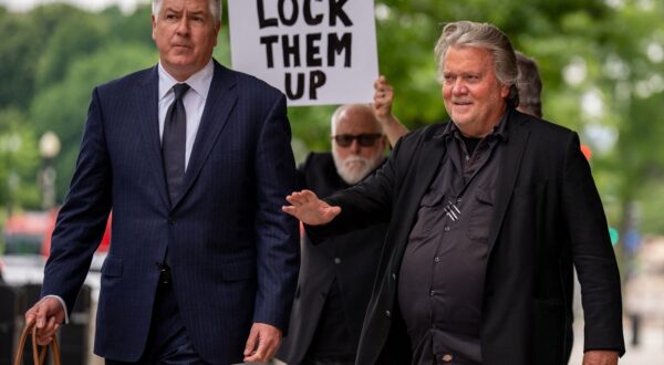 WASHINGTON, DC - JUNE 6: A man holds a sign that reads "Lock Them Up" as Attorney Matthew Evan Corcoran (L) and Steve Bannon, former advisor to President Donald Trump, depart federal court on June 6, 2024 in Washington, DC. Bannon has been ordered to begin serving his four-month prison sentence on July 1 for two counts of contempt of Congress after failing to comply with a congressional subpoena related to the Jan. 6, 2021, attack on the U.S. Capitol.   Andrew Harnik,Image: 879436414, License: Rights-managed, Restrictions: , Model Release: no, Credit line: Andrew Harnik / Getty images / Profimedia