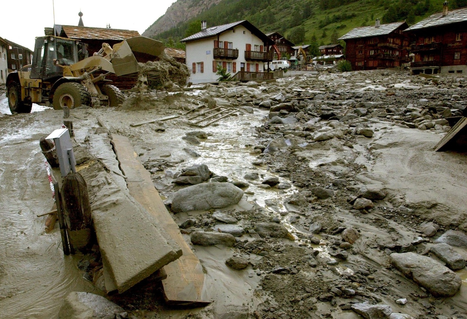 Heavy machinery (L) is used to clear the debris and rubble in overflooded parts of the village of Taesch, near Zermatt, Switzerland, 26 June 2001. An avalanche caused the lake Weingartensee, situated above Taesch, to overflow, spilling water and debris into the village late yesterday evening. Some 150 people were evacuated temporarily.,Image: 69127525, License: Rights-managed, Restrictions: , Model Release: no, Credit line: ANDREE-NOELLE POT / AFP / Profimedia