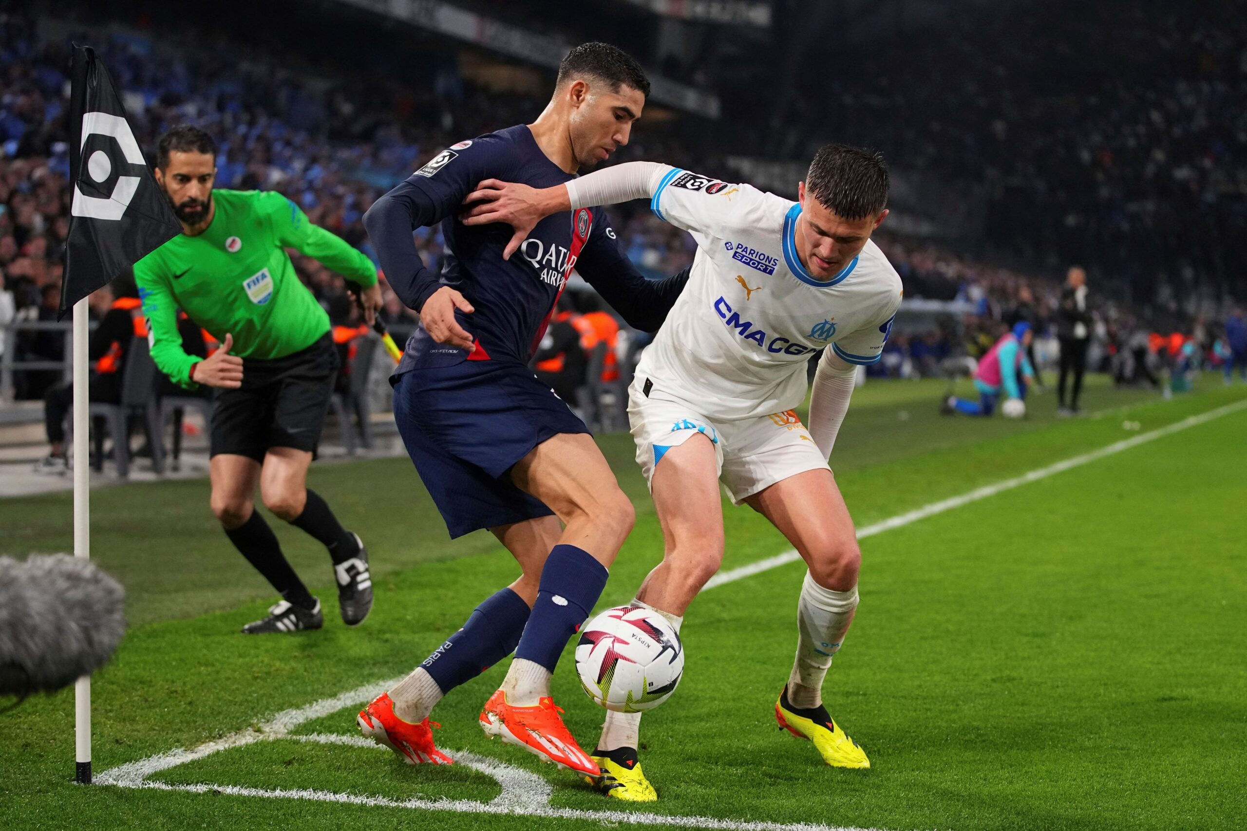 PSG's Achraf Hakimi, left, challenges Marseille's Quentin Merlin