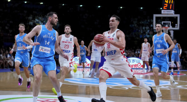 Croatia's Mario Hezonja, right, advances with the ball against Greece's Georgios Papagiannis, during a FIBA Olympic Qualifying basketball final, at the Peace and Friendship stadium, at Athens' port city of Piraeus, Sunday, July 7, 2024. (AP Photo/Petros Giannakouris)