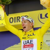 epa11452659 Slovenian rider Tadej Pogacar of UAE Team Emirates celebrates in the overall leader's yellow jersey on the podium after winning the fourth stage of the 2024 Tour de France cycling race over 139km from Pinerolo to Valloire, France, 02 July 2024.  EPA/KIM LUDBROOK