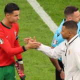 epa11460549 Cristiano Ronaldo of Portugal (L) shakes hands with Kylian Mbappe of France ahead of the UEFA EURO 2024 quarter-finals soccer match between France and Portugal, in Hamburg, Germany, 05 July 2024.  EPA/ABEDIN TAHERKENAREH