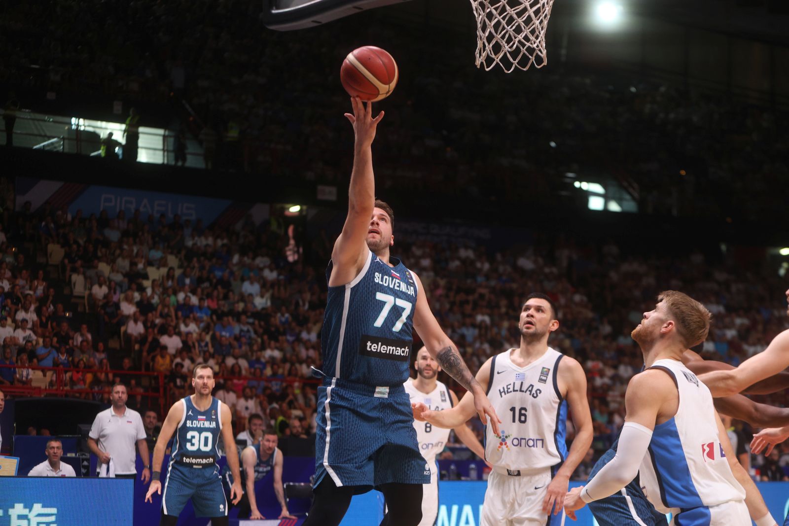 epa11462498 Slovenia's Luka Doncic (C) in action during the FIBA 2024 Pre-Olympic Tournament basketball game between Greece and Slovenia at Peace & Friendship Stadium in Piraeus, Greece, 06 July 2024.  EPA/GEORGIA PANAGOPOULOU