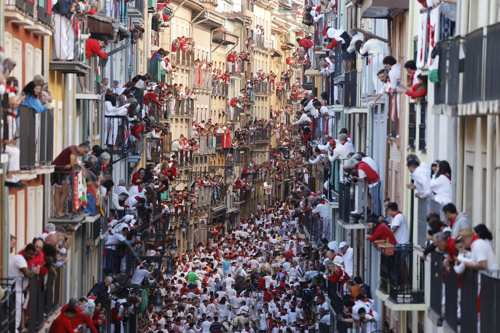 epa11464325 People gather during the running of the bulls of San Fermin festival (known as 'Sanfermines') in Pamplona, northern Spain, 07 July 2024. The San Fermin festival 2024 runs from 06 to 14 July, with the running of the bulls as main event.  EPA/VILLAR LOPEZ