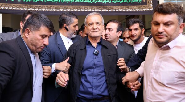 epa11461407 (FILE) - Iranian reformist presidential candidate Masoud Pezeshkian (C) is escorted after casting his vote at a polling station during the presidential election in Ghaleh Hasan Khan, Iran, 05 July 2024 (reissued 06 July 2024). According to a statement issued by the Ministry of Interior, Masoud Pezeshkian won the presidential runoff election, held in the wake of the death of late Iranian President Ebrahim Raisi, whom died in a hellicopter crash. Iran held the second round of its presidential election on 05 July 2024.  EPA/STR
