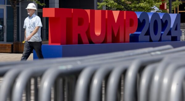 epa11476666 A person walks past signage for the Republican National Convention at Fiserv Forum in Milwaukee, Wisconsin, USA, 13 July 2024. Republicans will gather for their convention starting on 15 July and will officially confirm Donald J. Trump as the partyâ€™s candidate for President of the United States.  EPA/JUSTIN LANE