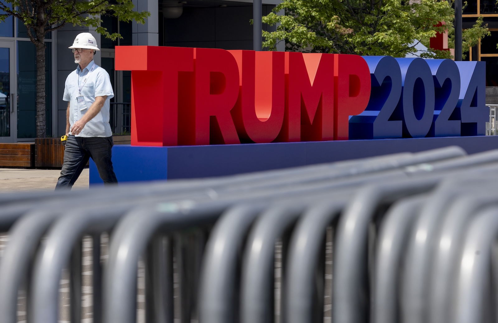 epa11476666 A person walks past signage for the Republican National Convention at Fiserv Forum in Milwaukee, Wisconsin, USA, 13 July 2024. Republicans will gather for their convention starting on 15 July and will officially confirm Donald J. Trump as the partyâ€™s candidate for President of the United States.  EPA/JUSTIN LANE