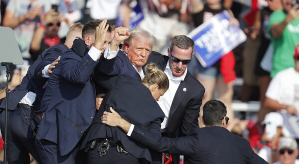 epa11476785 Former US President Donald Trump pumps his fist as he is rushed from stage by secret service after an incident during a campaign rally at the Butler Farm Show Inc. in Butler, Pennsylvania, USA, 13 July 2024. Trump was rushed off stage by secret service after an incident during a campaign rally in Pennsylvania. According to the Butler County district attorney a suspected gunman was dead and at least one rally attendee was killed. According to a statement by a secret service spokesperson, the former President is safe and further information on the incident will be released when available.  EPA/DAVID MAXWELL