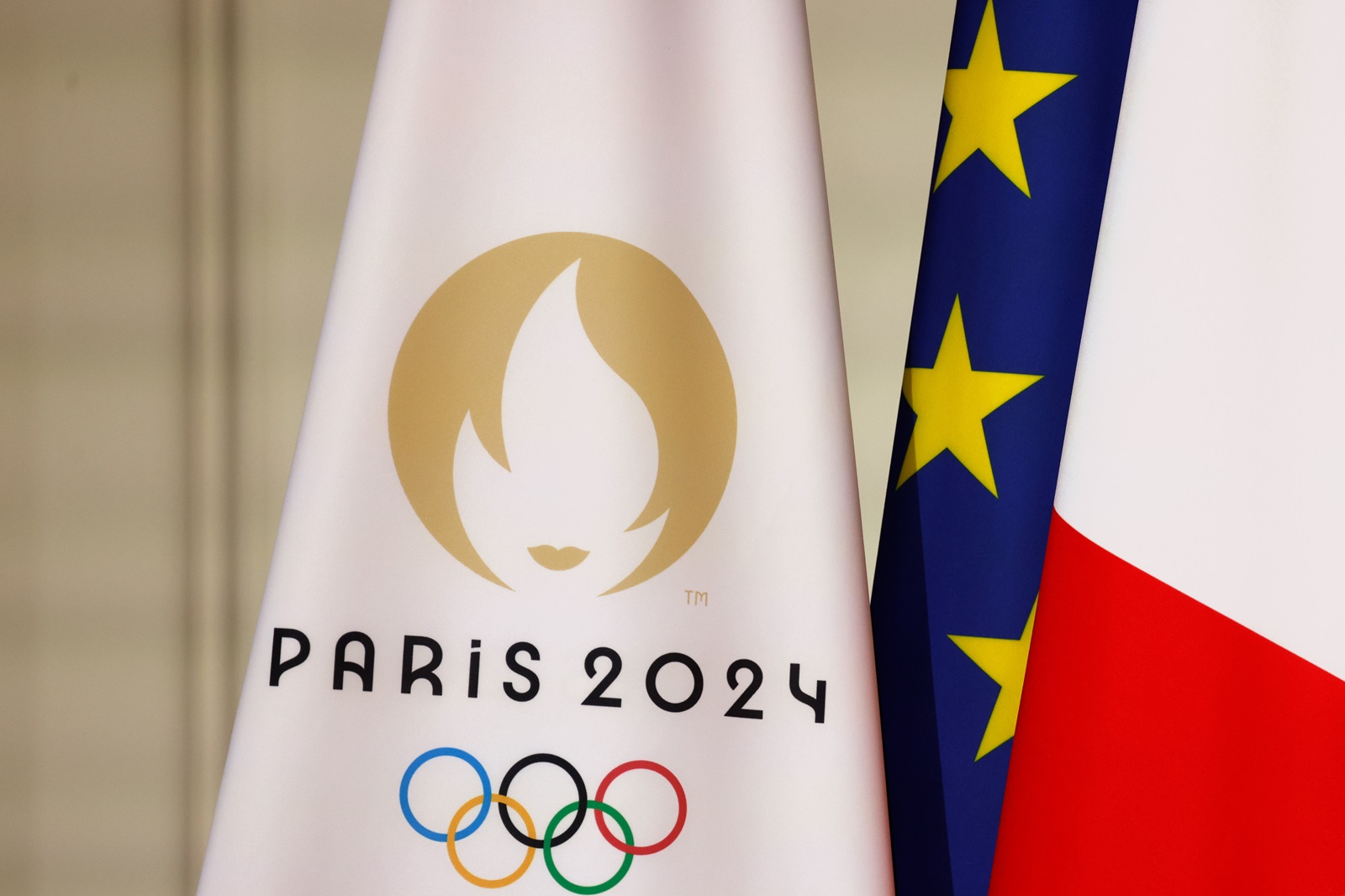 epa11491639 A flag with the Paris 2024 logo (L), a EU flag (C) and a French flag (R), displayed during a reception for international journalists accredited for the Paris 2024 Olympic Games, at the Elysee Presidential Palace, in Paris, France, 22 July 2024, ahead of Paris 2024 Olympic and Paralympic games.  EPA/LUDOVIC MARIN / POOL  MAXPPP OUT