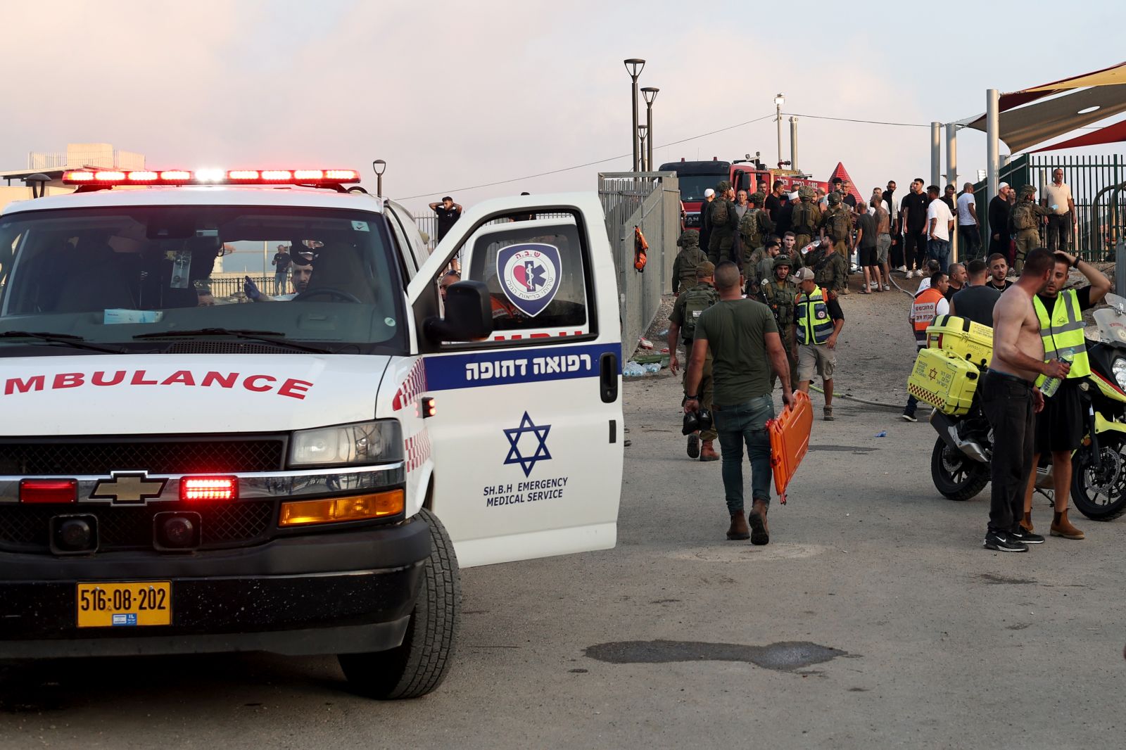 epa11500449 Soldiers, emergency services and civilians at the site where a projectile hit a playground in Druze, Majdal Shams, in the annexed Golan Heights, 27 July 2024. According to the Israel Defence Forces (IDF), a rocket launched from Lebanon toward Majdal Shams caused multiple civilian casualties, including children. Approximately 30 projectiles were identified crossing from Lebanon, the IDF said.  EPA/ATEF SAFADI