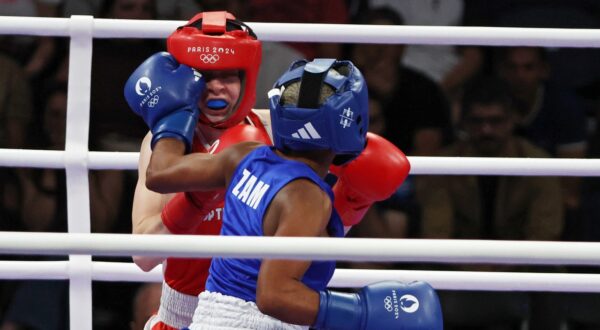 epa11504581 Pihla Kaivo OJa of Finland (red) and Margaret Tembo of Zambia (blue) fighht in their Women 50kg Preliminaries Round of 16 bout of the Boxing competitions in the Paris 2024 Olympic Games, at the North Paris Arena in Villepinte, France, 28 July 2024.  EPA/YAHYA ARHAB