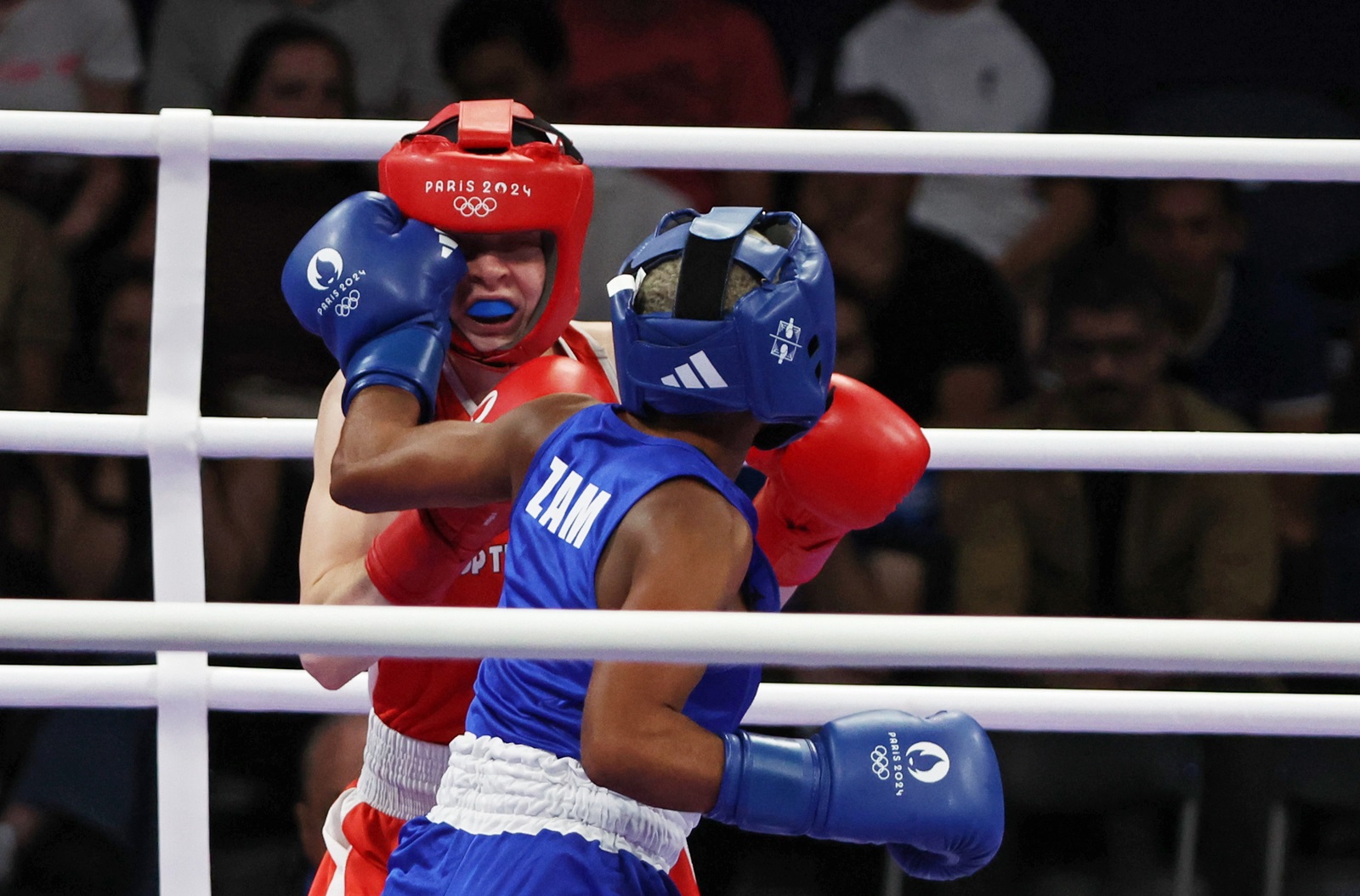 epa11504581 Pihla Kaivo OJa of Finland (red) and Margaret Tembo of Zambia (blue) fighht in their Women 50kg Preliminaries Round of 16 bout of the Boxing competitions in the Paris 2024 Olympic Games, at the North Paris Arena in Villepinte, France, 28 July 2024.  EPA/YAHYA ARHAB