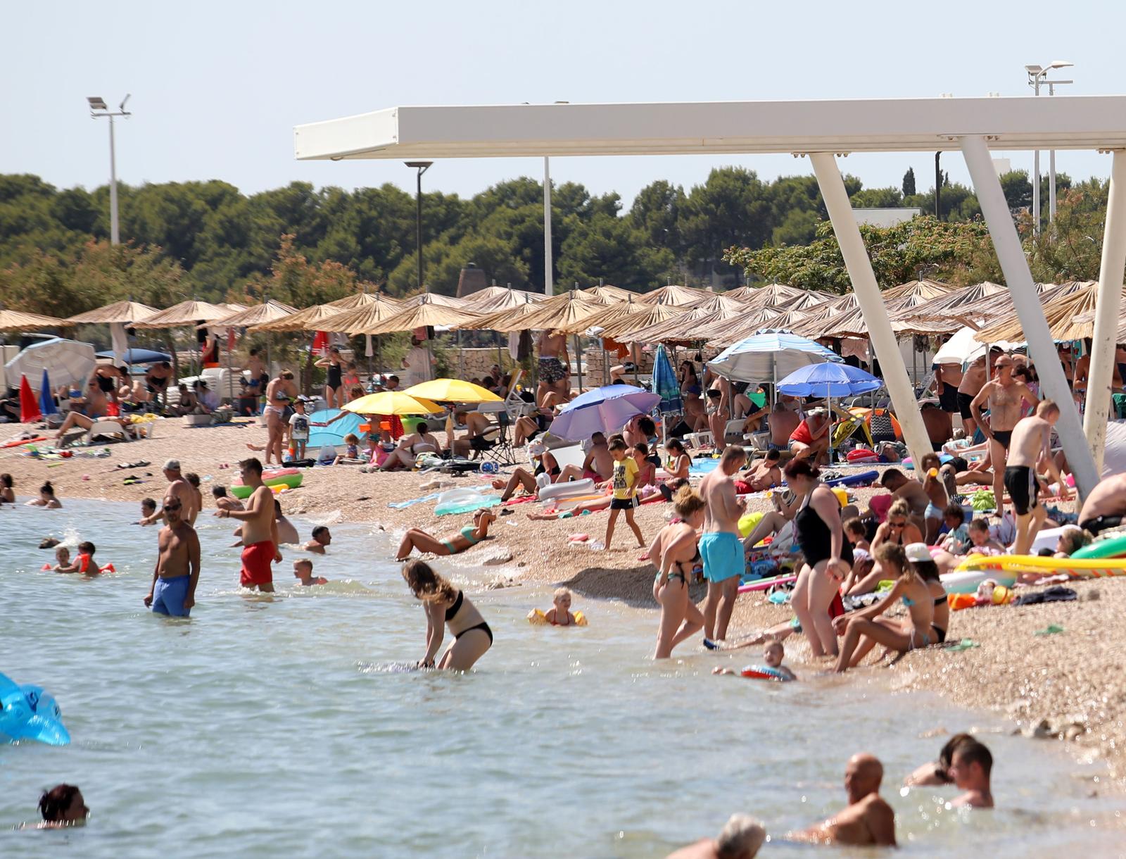 15.07.2024., Brodarica, Sibenik - Turisti i gradjani osvjezenje od vrucine pronasli na plazi Rezaliste. Photo: Dusko Jaramaz/PIXSELL