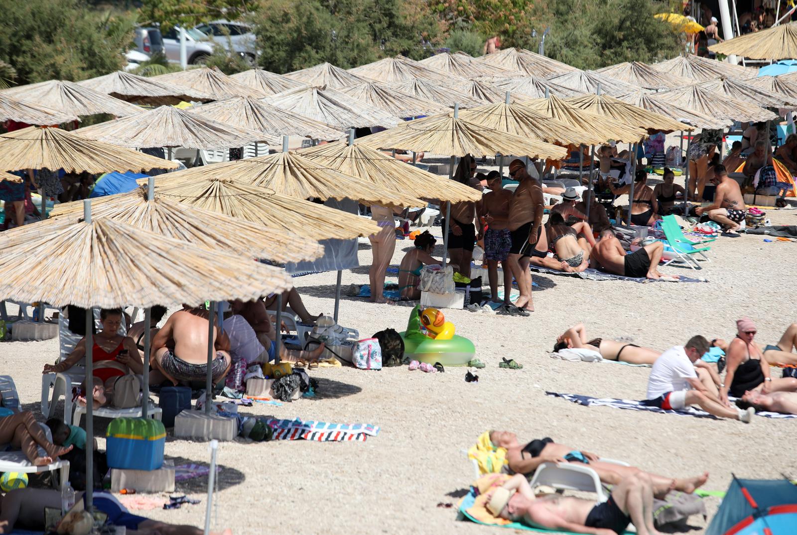 15.07.2024., Brodarica, Sibenik - Turisti i gradjani osvjezenje od vrucine pronasli na plazi Rezaliste. Photo: Dusko Jaramaz/PIXSELL