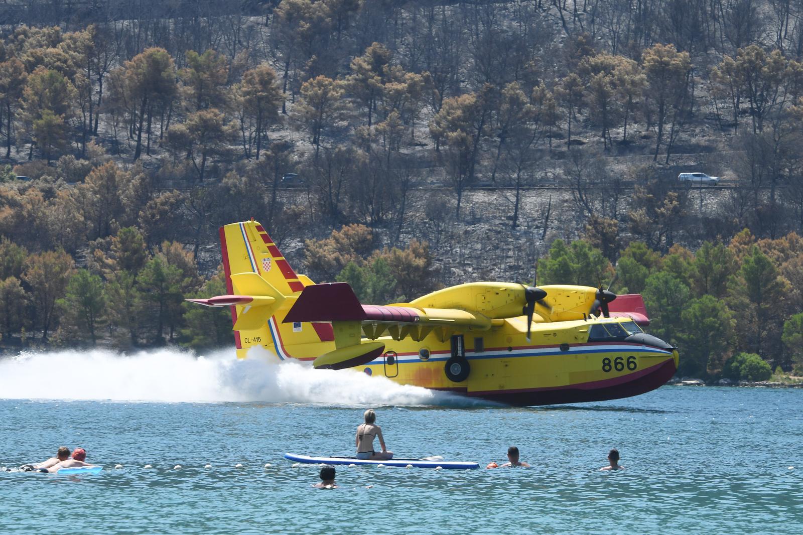 16.07.2023., Grebastica - Gaseci novi pozar u Grebastici piloti kanadera odsevljavali kupace na lokalnoj plazi svojim manevarskim sposobnostima. Photo: Hrvoje Jelavic/PIXSELL