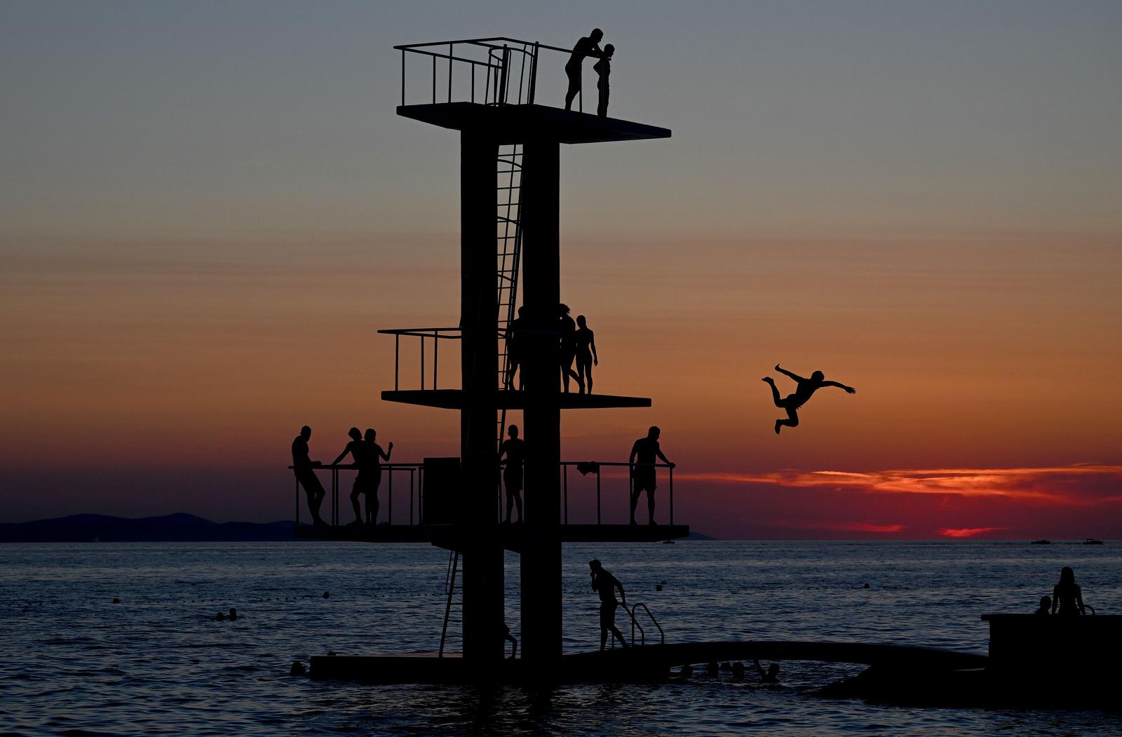 17.07.2024., Zadar - Bijeg od velikih vrucina mnogi su potrazili romanticnim skokom u more na glavnoj gradskoj plazi. Photo: Marko Lukunic/PIXSELL